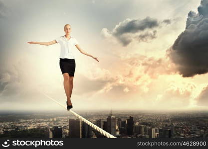 Businesswoman balancing on rope. Image of pretty businesswoman balancing on rope