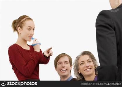 Businesswoman blowing whistle with three business executives beside her