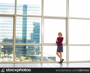 Businesswoman by window in office building portrait