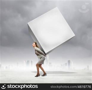 Businesswoman carrying cube. Image of businesswoman carrying big white cube on her back. Place for text