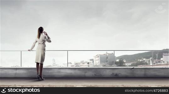 Businesswoman chat on mobile phone. Young elegant businesswoman on building top talking on mobile phone