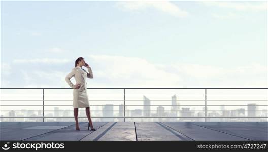 Businesswoman chat on mobile phone. Young elegant businesswoman on building top talking on mobile phone