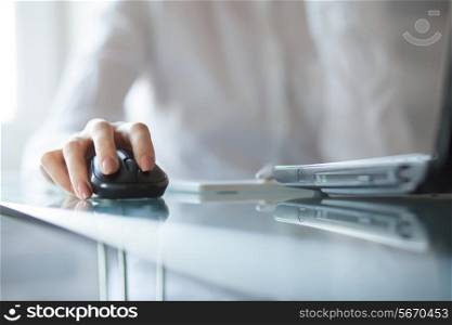 Businesswoman clicking on cordless mouse