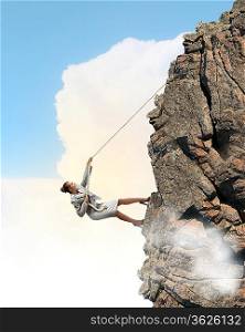 businesswoman climbing steep mountain hanging on rope