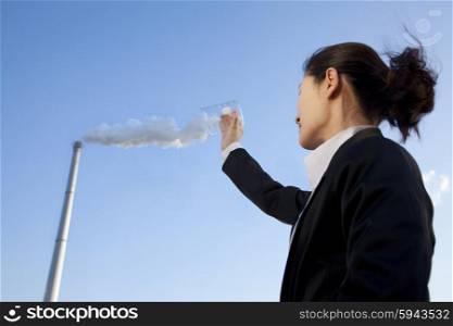 Businesswoman Collecting Smoke in Beaker
