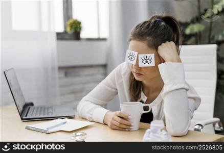 businesswoman covering her eyes with drawn eyes paper