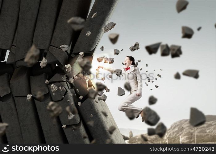 Businesswoman crashing bricks. Determined businesswoman breaking stone bricks with hand punch