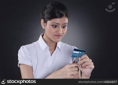 Businesswoman cutting credit card with scissors