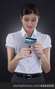 Businesswoman cutting credit card with scissors