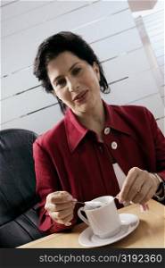Businesswoman dipping tea bag in a cup