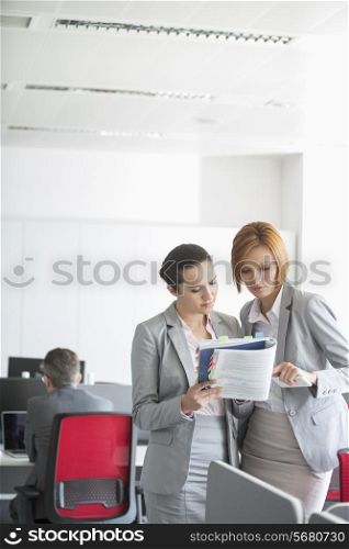 Businesswoman discussing over book in office