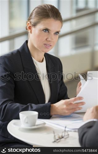 Businesswoman discussing with colleague during coffee break