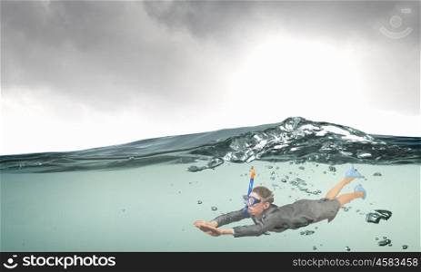 Businesswoman diver in mask. Young businesswoman in suit and diving mask swimming under water
