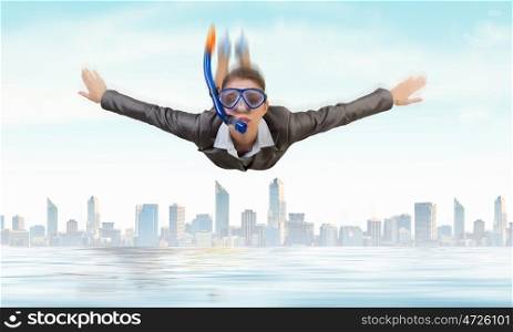 Businesswoman diver. Young businesswoman in suit and diving mask flying in sky
