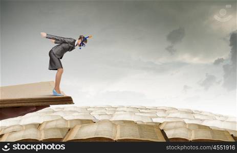 Businesswoman diver. Young businesswoman in suit and diving mask jumping in books