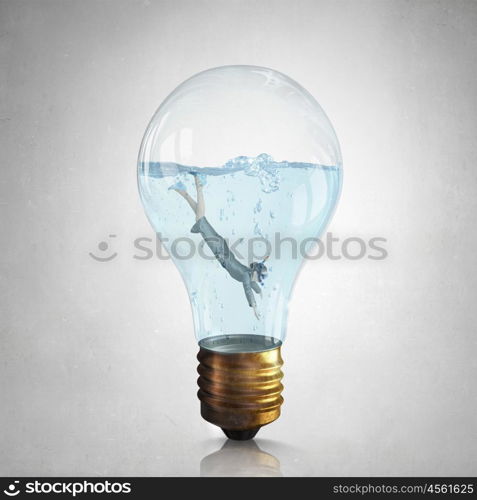 Businesswoman diver. Young businesswoman in suit and diving mask jumping in lightbulb with water