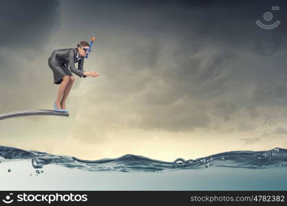 Businesswoman diver. Young businesswoman in suit and diving mask jumping in water