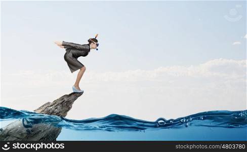 Businesswoman diver. Young businesswoman in suit and diving mask jumping in water
