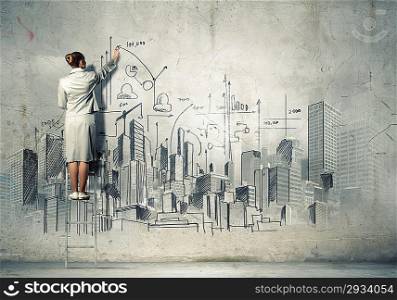 Businesswoman drawing on wall