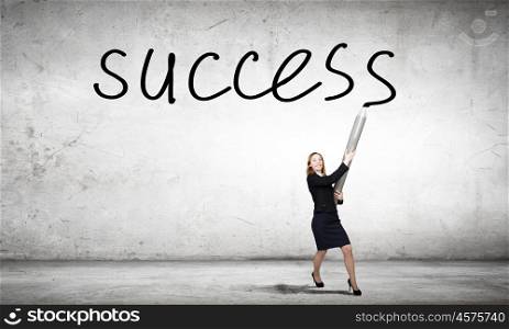 Businesswoman drawing word success with huge pencil. My great idea