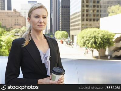 Businesswoman Drinking Takeaway Coffee Outside Office