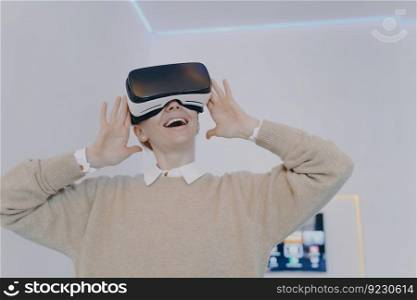 Businesswoman enjoying cyberspace in 3d virtual goggles. Young european woman in VR headset in office. Virtual reality design visualisation. Excitement from futuristic corporate innovation concept.. Businesswoman enjoying cyberspace in 3d virtual goggles. Excitement from futuristic innovation.