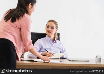 Businesswoman executive is in meeting discussion with another businesswoman in modern workplace office. People corporate business team concept.