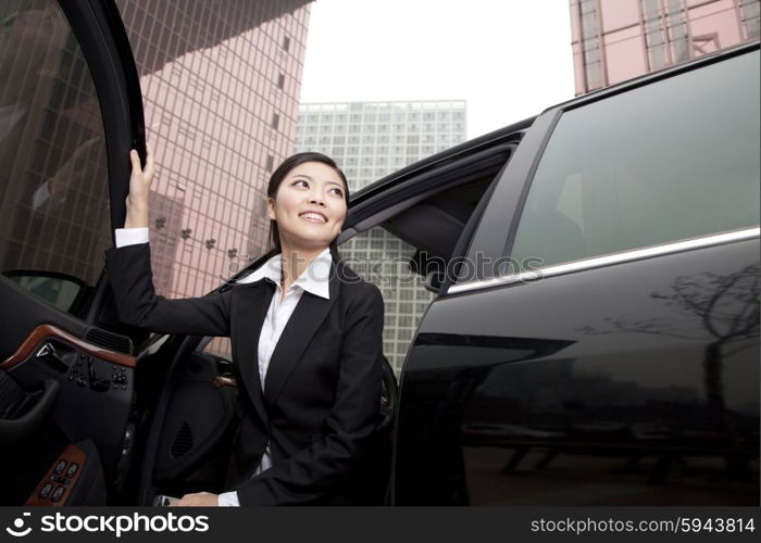 Businesswoman exiting a car