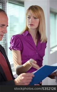 Businesswoman explaining document to colleague