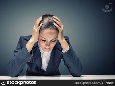 Businesswoman facing problems. Young troubled businesswoman with hands on head