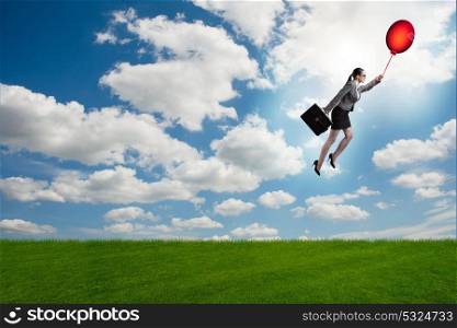 Businesswoman flying balloons on bright day