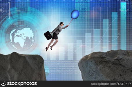 Businesswoman flying holding balloon