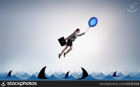 Businesswoman flying holding balloon