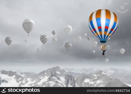 Businesswoman flying in search of ideas hanging on balloon. Search for new business ideas