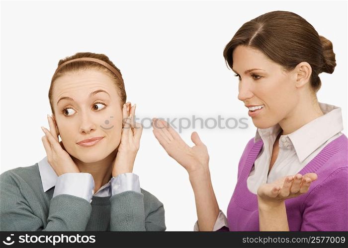 Businesswoman gesturing with her colleague ignoring her