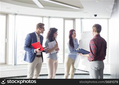 Businesswoman giving presentation to colleagues in creative office