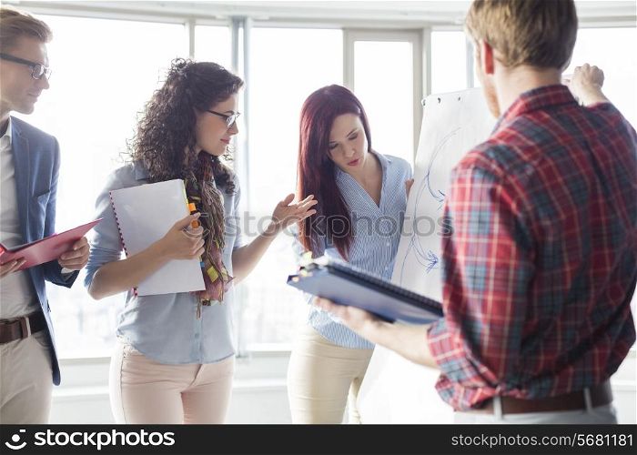 Businesswoman giving presentation to colleagues in creative office