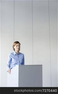Businesswoman giving speech at podium in office