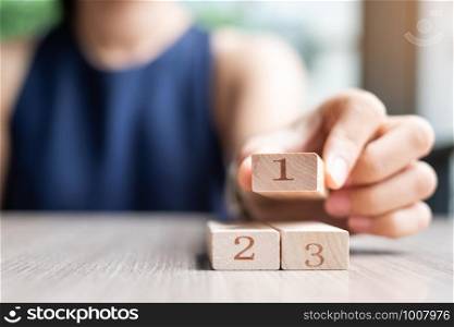 Businesswoman hand placing or pulling 1 st wooden block on the building. Business planning, Risk Management, Solution and strategy Concepts