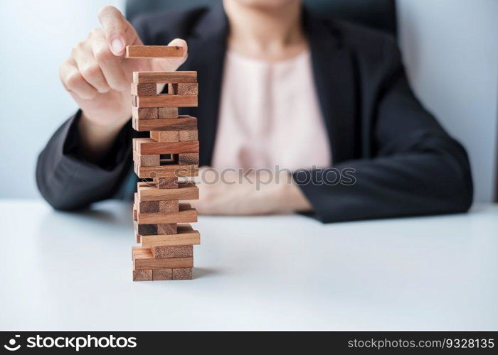 Businesswoman hand placing or pulling wooden block on the tower. Business planning, Risk Management, Solution and strategy Concepts