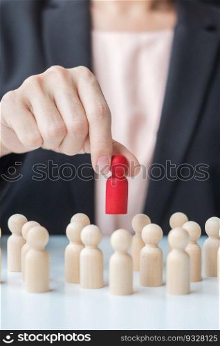 Businesswoman hand pulling leader man wooden from crowd of employees. Toxic People, Human resource management, Recruitment, Teamwork and leadership Concepts
