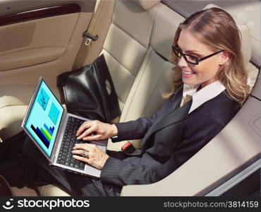businesswoman has a fan with laptop in black car