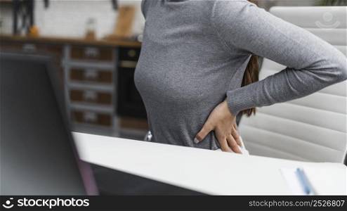 businesswoman having backache while working from home