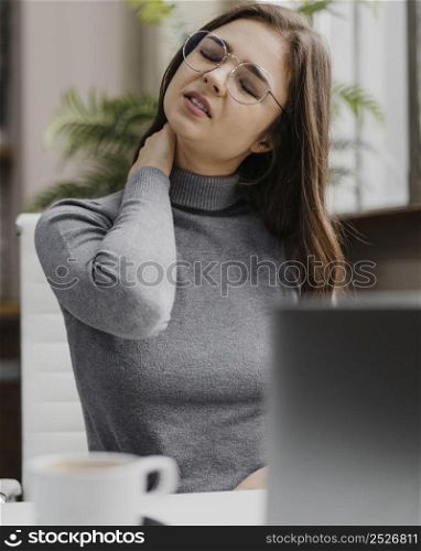 businesswoman having neckache while working from home