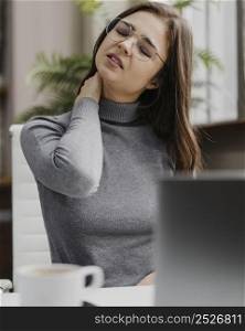 businesswoman having neckache while working from home