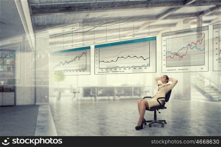 Businesswoman having rest in office. Young relaxed businesswoman sitting relaxed in chair in office
