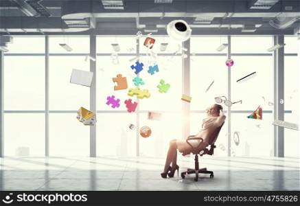Businesswoman having rest in office. Young relaxed businesswoman sitting relaxed in chair in office