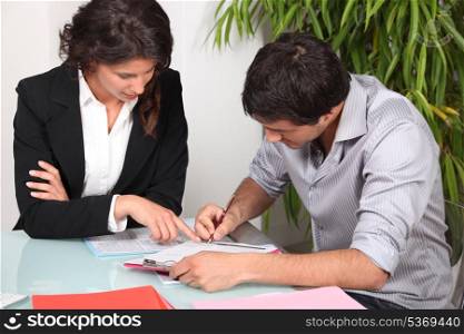 Businesswoman helping her client fill in paperwork