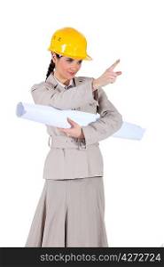 businesswoman holding a blueprint and pointing at something