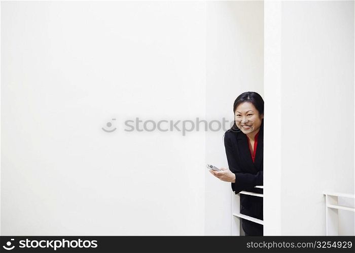 Businesswoman holding a mobile phone and smiling